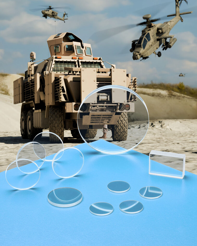 ZINC SULFIDE LENSES & WINDOWS IDEAL WHERE THERMAL CONTRAST IS CRITICAL Many Zinc Sulfide windows and lenses in different configurations sit on a blue table in front of military vehicles using guidance systems.